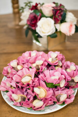 a tray with sweets and vases with red and white flowers on top of a table