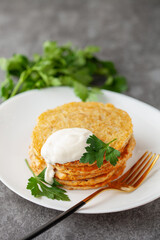 Potatoes pancakes latkes, flapjacks, hash brown or potato vada with parsley and sour cream  on table.