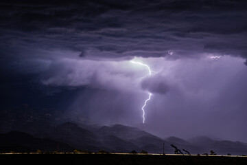 Lightning strikes a mountain at night - obrazy, fototapety, plakaty