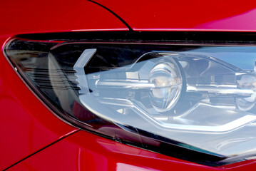 The headlight of a red car