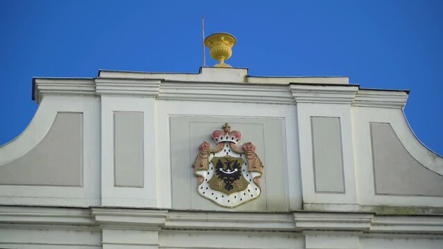 zooming in to an erb hanging on the top of the wall of an romance gothic building in czech republic golden structure on top of the roof travel documentary city town location