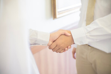 Close up of two businessmen shake hands after a business deal in the office.