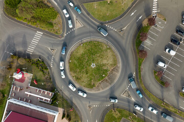 Aerial view of road roundabout intersection with fast moving heavy traffic. Urban circular transportation crossroads