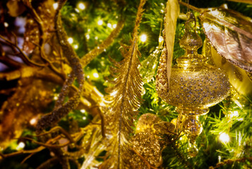 Christmas ornaments on a green tree with tinsel and lights