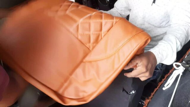 A Labour Installing Or Wearing Brown Leather Car Seat Cover At Shop. Leather Seat Cover