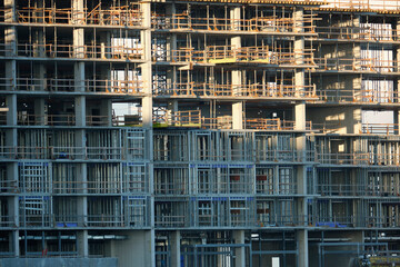 Fototapeta na wymiar Tower cranes and frame structure of high residential apartment buildings at construction site. Real estate development