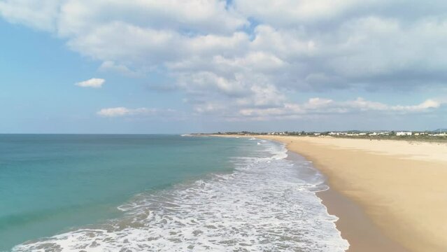 Aerial flying over the coastline sea waves on beach in Los Canos de Meca Spain