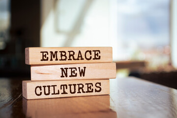 Wooden blocks with words 'Embrace New Cultures'.