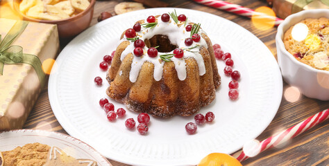 Tasty Christmas cake with cranberries on wooden table