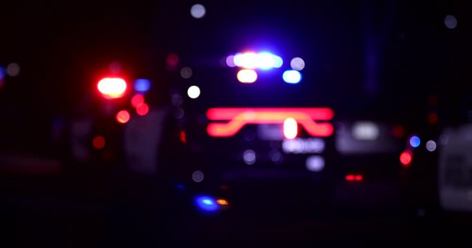 Abstracted night time bokeh view of police units responding to the scene of an emergency.