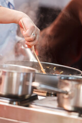 Cooks prepare meals on the stove in the kitchen of the restaurant or hotel.