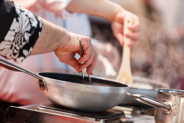Cooks prepare meals on the stove in the kitchen of the restaurant or hotel.