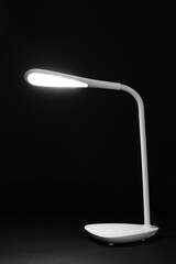Glowing white lamp on black background