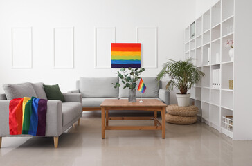 Interior of light living room with sofas, LGBT flag and painting