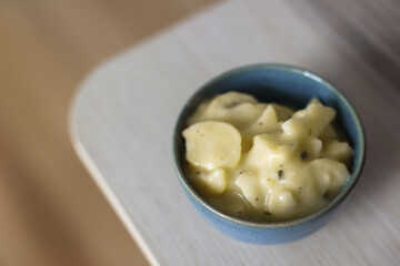 Bowl with creamy potato salad on wooden table