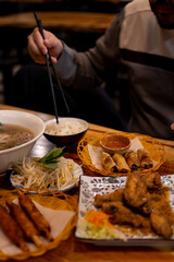 A spread of Vietnamese food including a hot bowl of pho