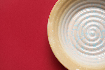 Stylish empty plate on red background, closeup