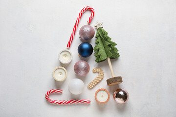 Christmas tree made of decor, candles and treats on white background
