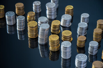 Piles of coins (polish zloty, grosze, PLN) on a black, reflective surface. Inflation consuming our...
