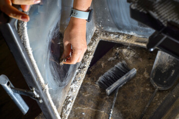 young woman cleaning fireplace glass doors. Close up of young woman is cleaning the fireplace. Modern fireplace with glass.