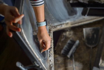 young woman cleaning fireplace glass doors. Close up of young woman is cleaning the fireplace. Modern fireplace with glass.