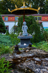 Religious statue in garden with golden umbrella