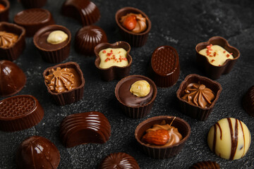 Different chocolate candies on black background, closeup