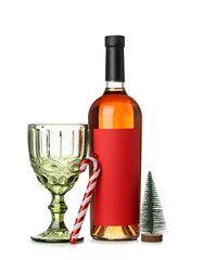 Bottle of wine with glass and Christmas toys on white background