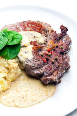 beef steak with sauce, mashed potatoes and spinach leaves