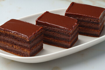 Three piece of chocolate brownie cake on white plate