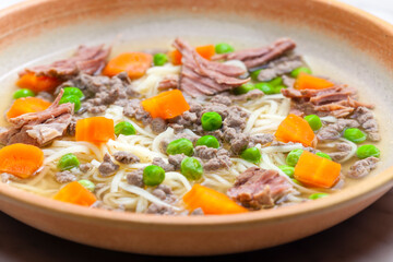 beef broth with green peas, carrot and small meatballs