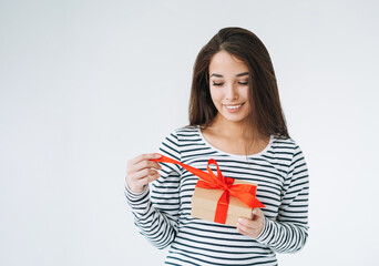Portrait of young smiling asian woman with gift box in hands on white background isolated