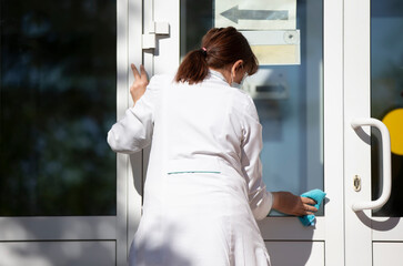 Cleaning lady in the hospital washes the front door