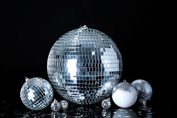 Disco ball with Christmas decor and confetti on black background