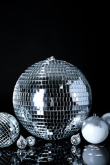Disco ball with Christmas decor and confetti on black background