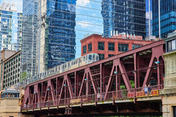 Travel train in Chicago going over bridge by skyscrapers