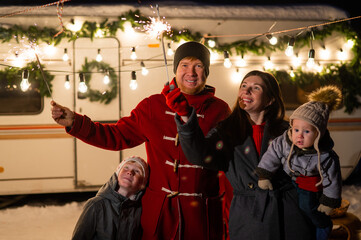 Happy parents with two sons celebrating christmas in motorhome. 