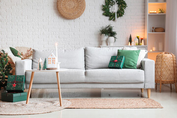 Interior of living room with sofa, Christmas presents and candle holders