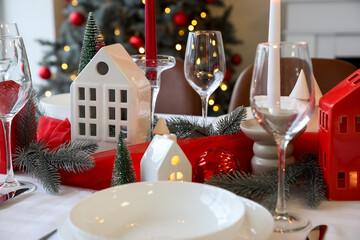 Christmas table setting with candle holders and fir branches in dining room, closeup