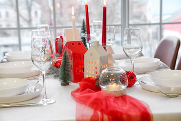 Christmas table setting with candle holders and fir branches in dining room, closeup