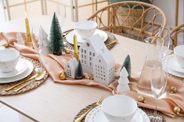 Table setting with candle holders and Christmas trees in dining room