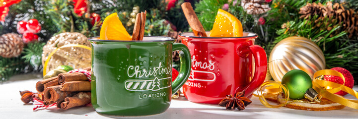 Christmas winter mulled wine drink. Classic style mulled red wine cocktail with orange slice, cinnamon, spices, on festive Christmas, New Year Noel decorated wooden background copy space