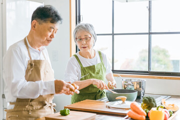高齢者男性の料理に心配して教えるアジア人高齢者女性（困る）
