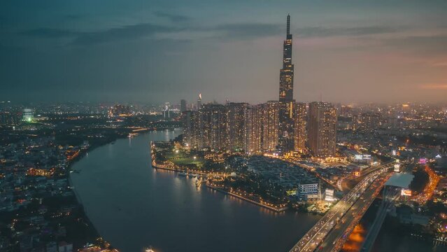 Aerial hyper lapse of Landmark 81 skyscraper and Ho Chi Minh city skyline in sunset to night and moving traffic on street. Landscape and business concept
