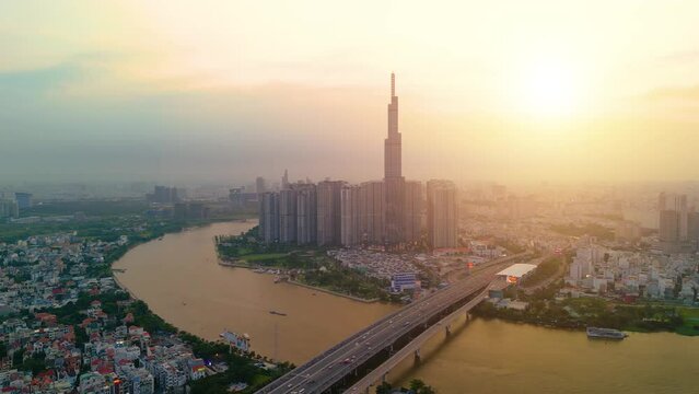 Aerial view of Landmark 81 skyscraper and Ho Chi Minh city skyline in sunset and moving traffic on street. Landscape and business concept
