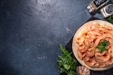 Cooking diet white poultry meat background. Fresh sliced chicken strips raw for cooking, with spices, herbs, on a black concrete background top view copy space