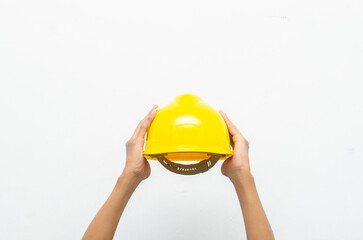 Male hand holding yellow safey hard hat isolated over white background. work safety concept. labour day concept.	
