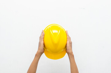 Male hand holding yellow safey hard hat isolated over white background. work safety concept. labour day concept.	
