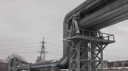 pipeline and power line in the city in winter against the gray sky.