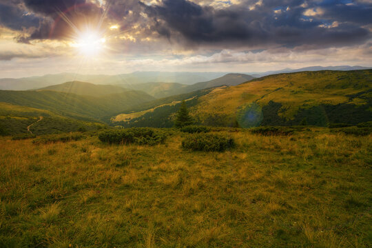 picturesque view of carpathian mountains at sunset. green landscape with hills rolling in to the distant ridge. alpine meadows beneath a sky with clouds in evening light